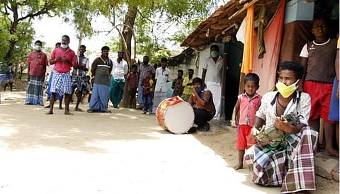 பட விளக்கம்: பாண்டியூர் கிராமத்தில் கரோனா நிவாரண நிதி கோரி மேள தாளங்களை இசைத்த நாட்டுப்புற கலைஞர்கள்.