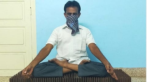 கரோனா தொற்றிலிருந்து மக்கள் விடுபட ஆணிப் படுக்கையில் தியானம்: யோகாசன பயிற்றுனர் நூதனம்