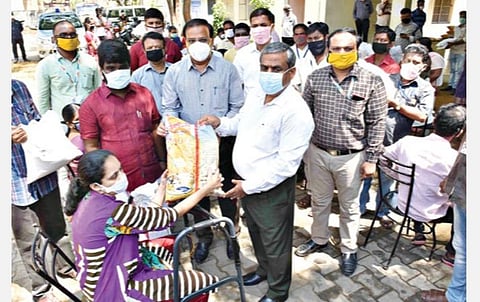 கோவையில் நேற்று மாற்றுத் திறனாளிகளுக்கு அத்தியாவசியப் பொருட்கள் வழங்கிய மாவட்ட ஆட்சியர் கு.ராசாமணி. அருகில், மண்டல கண்காணிப்பு அலுவலர் ஞானசேகரன் உள்ளிட்டோர். 			    படம்: ஜெ.மனோகரன்