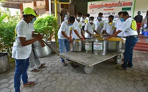 பொதுமக்களுக்கு வழங்குவதற்காக உணவை எடுத்துச் செல்லும் தன்னார்வலர்கள்.