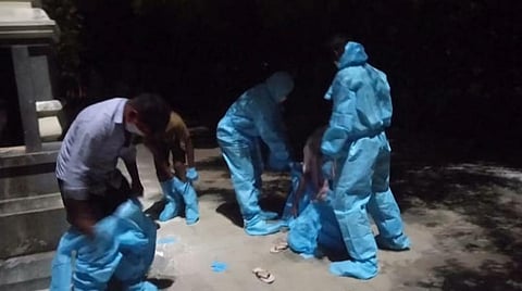 விழுப்புரம் நகராட்சி மின்மயானமான 'முக்தி'யில் மூதாட்டியின் உடல் எரியூட்டப்பட்ட பின்பு கரோனா வைரஸ் தடுப்பு கவச உடைகளை அகற்றும் சுகாதாரத்துறையினர்.