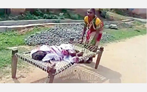 ஒடிசாவில் வங்கிக்கு கட்டிலுடன் இழுத்துச் செல்லப்படும் மூதாட்டி.