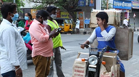 திருச்சி தில்லைநகர் பகுதியில் முகக்கவசம் அணியாமல் இருசக்கர வாகனத்தில் வந்த ஒருவருக்கு அபராதம் விதிக்கும் மாநகராட்சிப் பணியாளர்கள்.