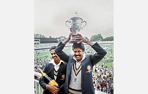 கோப்பையுடன் கபில், அருகில் மொஹீந்தர் அமர்நாத்: கெட்டி இமேஜஸ்.