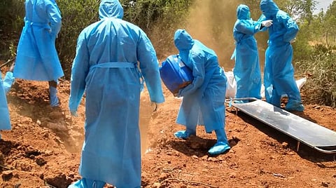 கந்தர்வக்கோட்டை அருகே கரோனாவால் உயிரிழந்த சிறுவனை அடக்கம் செய்யும் பணியில் ஈடுபட்ட அலுவலர்கள்.