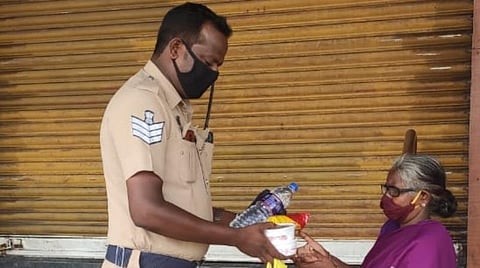 பழனியம்மாளுக்கு உதவும் தலைமைக் காவலர் திருமுருகன்.