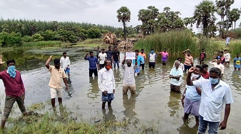 ஏரியை மீட்டெடுக்க வேண்டி ஏரியில் இறங்கி போராட்டம் நடத்தும் கிராம மக்கள்.