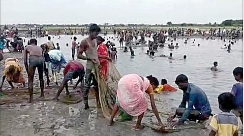 விழுப்புரம் அருகே கல்பட்டு கிராமத்தில் நடைபெற்ற மீன்பிடித் திருவிழாவில் பங்கேற்ற கிராம மக்கள்.