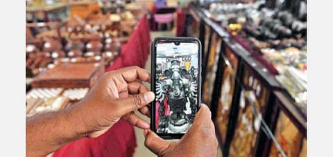 கோவை பூம்புகார் விற்பனை மையத்தில், செல்போன் செயலி மூலம் பொருட்களை காணும்முறை குறித்து விளக்கப்படுகிறது.    படம்: ஜெ.மனோகரன்