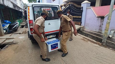 வேலூரில் நடத்தப்பட்ட சோதனையில் பறிமுதல் செய்யப்பட்ட பொருட்களை எடுத்துச் செல்லும் காவல்துறையினர்.