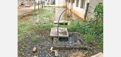 திறந்து கிடக்கும் தொட்டியில் உள்ள கழிவுநீருடன் கலந்து தேங்கியுள்ள தண்ணீர். | ஜி.ஞானவேல்முருகன்