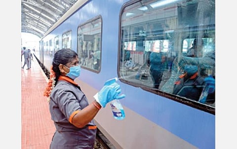 சென்னை எழும்பூர் ரயில் நிலையத்தில் கிருமிநாசினி தெளித்து ரயிலின் வெளிப் பகுதியை சுத்தப்படுத்தும் தொழிலாளர்.