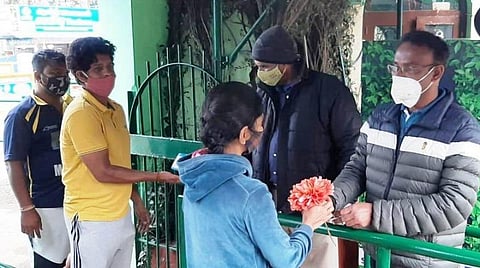 உதகை தாவரவியல் பூங்காவுக்கு வந்த சுற்றுலாப் பயணிகளுக்குப் பூக்களைக் கொடுத்து பூங்கா ஊழியர்கள் வரவேற்றனர்.