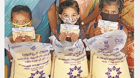 இலவச அரிசி மற்றும் ரொக்கம் ஆகியவை பெற்றுக்கொண்ட புதுச்சேரி சவரிராயலு அரசு பெண்கள் தொடக்கப் பள்ளி குழந்தைகள். படம்: எம்.சாம்ராஜ்