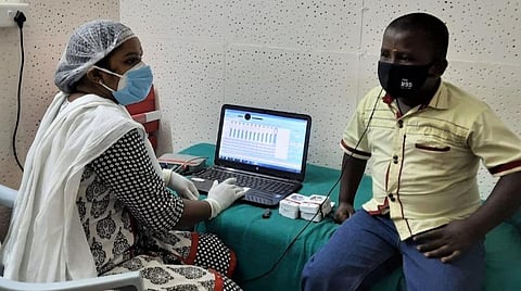 கோவை அரசு மருத்துவமனையில் அறுவை சிகிச்சை மூலம் சிறுவனுக்குப் பொருத்தப்பட்ட கருவியின் செயல்பாட்டைப் பரிசோதிக்கும் பேச்சுப் பயிற்சியாளர்.