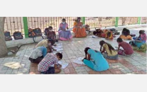 புதூர் அருகே மணியக்காரன்பட்டி ஊராட்சியில் பெற்றோரின் வேண்டுகோளை ஏற்று மரத்தடியில் அமர்ந்து மாணவ, மாணவிகளுக்கு பாடம் நடத்தும் ஆசிரியைகள்