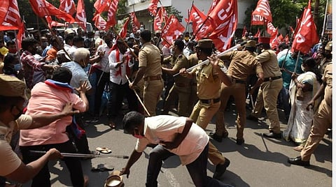 போலீஸார் தடியடியால் சிதறிக் கிடக்கும் பொருட்களை எடுக்க முற்படும் தொழிலாளர்கள். | படங்கள்- எம்.சாம்ராஜ்