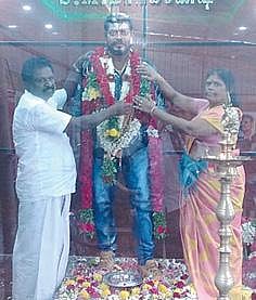 மகன் மாரிகணேஷ் மெழுகுச் சிலையுடன்  பெற்றோர்.