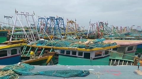 தொழிலுக்கு செல்லாததால் காரைக்கால் மீன்பிடி துறைமுகத்தில் நிறுத்தி வைக்கப்பட்டுள்ள விசைப்படகுகள்.