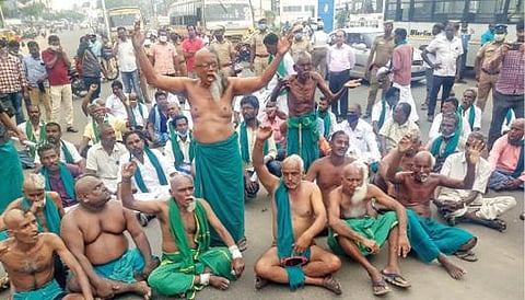 போராட்டம் நடத்த டெல்லி செல்ல விடாமல் தடுத்ததால் பாதி மொட்டை அடித்துக்கொண்டு திருச்சியில் நேற்று சாலை மறியலில் ஈடுபட்ட தேசிய- தென்னிந்திய நதிகள் இணைப்பு விவசாயிகள் சங்கத்தினர்.