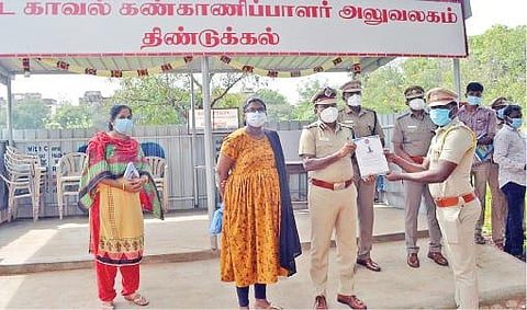 திண்டுக்கல் மாவட்டத்தில் கரோனா பாதிப்பு சிகிச்சை முடிந்து பணிக்கு திரும்பிய காவலருக்கு சான்றிதழ் வழங்கிய டி.ஐ.ஜி. முத்துச்சாமி. அருகில் மாவட்ட எஸ்.பி, ரவளிபிரியா.