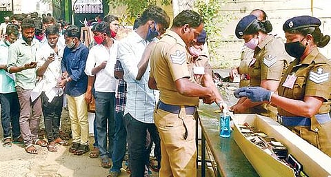 திருச்சி இ.ஆர். பள்ளி வளாகத்தில் நேற்று நடைபெற்ற இரண்டாம் நிலை காவலர்களுக்கான எழுத்துத் தேர்வில் பங்கேற்க வந்தவர்களிடம் இருந்து செல்போன்களை வாங்கி சேகரித்துவைக்கும் போலீஸார்.படம்: ஜி.ஞானவேல்முருகன்