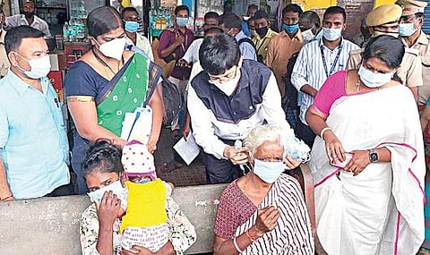 செங்கல்பட்டு பேருந்து நிலையத்தில் கரோனா தொற்று தடுப்பு நடவடிக்கை குறித்து ஆய்வு மேற்கொண்ட சுகாதாரத் துறைச் செயலர் ஜெ.ராதாகிருஷ்ணன், முகக்கவசம் அணியாமல் இருந்த மூதாட்டிக்கு முகக்கவசம் அணிவித்தார்.