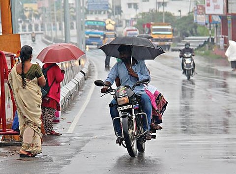 சேலத்தில் நேற்று அதிகாலை முதல் சாரல் மழை பெய்தது. திருவாக்கவுண்டனூர் பகுதியில் பெய்த மழையின்போது குடை பிடித்தவாறு செல்லும் வாகன ஓட்டி.
