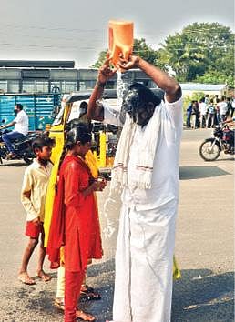 தி.மலை மாவட்ட ஆட்சியர் அலுவலக நுழைவு வாயில் முன்பு தீக்குளிக்க முயன்ற விவசாயி சரவணன்.