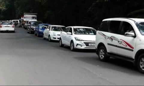 கொடைக்கானல் வெள்ளிநீர்வீழ்ச்சி அருகே நீண்டவரிசையில் காத்திருந்த வாகனங்கள்.