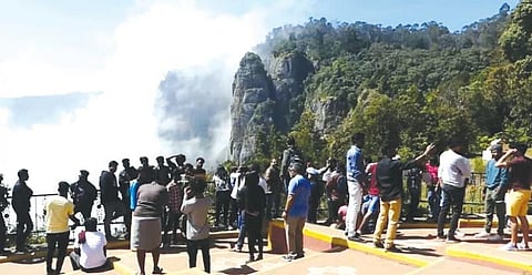 கொடைக்கானல் தூண் பாறைப் பகுதியில் இயற்கை எழிலை ரசிக்கும் சுற்றுலாப் பயணிகள்.