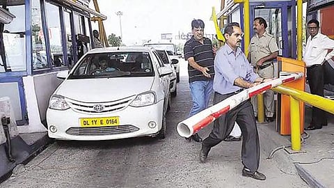 ஹரியாணா சுங்கச் சாவடியில் தடுப்பை அகற்றுகின்றனர்.