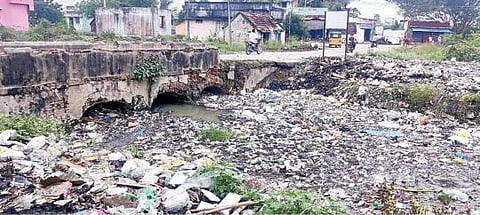 திருக்காலிமேடு பகுதியில் மஞ்சள் நீர் கால்வாயில் வடிகட்டி அமைக்க விவசாயிகள் கோரும் இடத்தில் தேங்கியுள்ள பிளாஸ்டிக் கழிவுகள்.