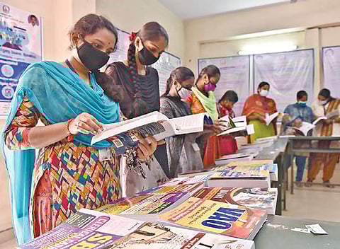 சேலம் கோரிமேடு அரசு மகளிர் கலைக்கல்லூரியில் தொழில்நெறி வழிகாட்டும் கண்காட்சி நேற்று நடைபெற்றது. இதில், இடம் பெற்ற புத்தகங்களை ஆர்வத்துடன் படித்த மாணவிகள்.		   	                    படம்: எஸ்.குரு பிரசாத்