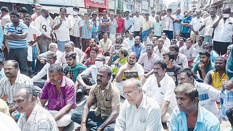 விருதுநகர் பஜார் சாலையில் அமர்ந்து மறியலில் ஈடுபட்ட வியாபாரிகள்.