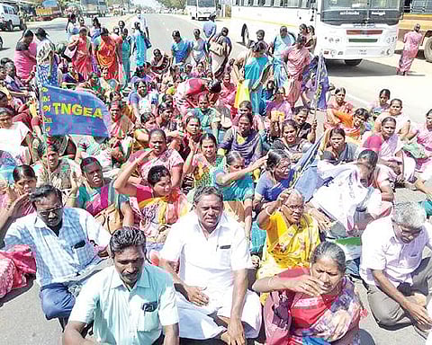 தேனியில் அரசு தொழிற்பயிற்சி நிலையம் அருகே சாலை மறியலில்  ஈடுபட்ட அரசு ஊழியர்கள்.