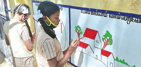 அரசுப் பள்ளி சுவரில் ஓவியம் வரையும் மாணவர்கள்