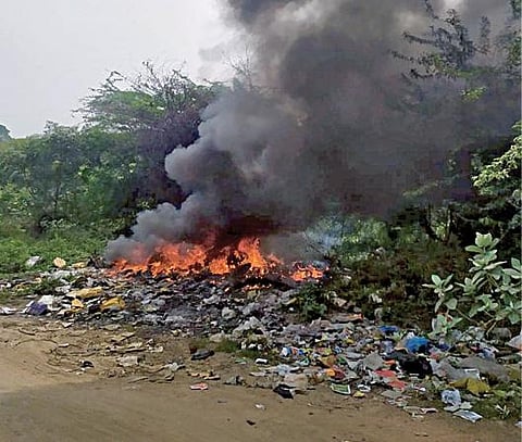 காக்களூர் ஆஞ்சநேயபுரம் பகுதியில் அமைந்துள்ள குடியிருப்புகளில்  சேகரிக்கப்படும் குப்பை  காக்களூர் - புட்லூர் சாலை ஓரத்தில் கொட்டி எரிக்கப்படுகிறது.