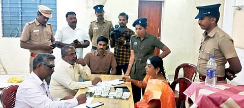 ஆரணியில் பறிமுதல் செய்யப்பட்ட பணத்தை சரிபார்க்கும் தேர்தல் அதிகாரிகள்.