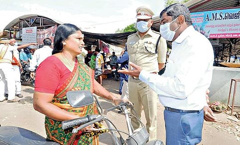ஈரோடு காய்கறிச்சந்தை அருகே முகக்கவசம் அணியாமல் வந்த பெண்ணிடம், கரோனா பாதிப்பு குறித்து ஆட்சியர் சி.கதிரவன் அறிவுரை வழங்கினார்.