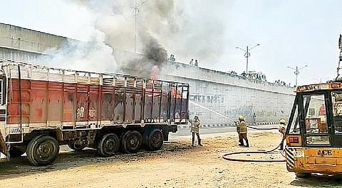 வேலூர் மாவட்ட ஆட்சியர் அலுவலகம் அருகே லாரியில் பற்றிய தீயை அணைக்கும் பணியில் ஈடுபட்ட தீயணைப்பு வீரர்கள்.