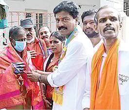 தூய்மைப் பணியாளருக்கு பொன்னாடை அணிவித்து வாக்கு சேகரித்த பாஜக வேட்பாளர் பாண்டுரங்கன்.