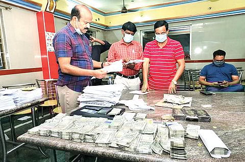 காட்பாடியில் அதிமுக பிரமுகர்களிடம் பறிமுதல் செய்யப்பட்ட பணம், லேப்டாப்  உள்ளிட்ட ஆவணங்களை பார்வையிட்ட மாவட்ட ஆட்சியர் சண்முகசுந்தரம்.