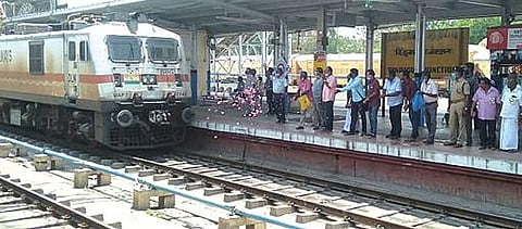 திண்டுக்கல் ரயில் நிலையத்துக்கு வந்த தேஜஸ் ரயிலை மலர் தூவி வரவேற்ற வர்த்தகர் சங்கத்தினர்.