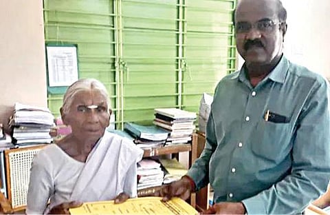 கமலாத்தாள் பெயரில் நிலம் பதிவு செய்த ஆவணத்தை அவரிடம் வழங்கிய  மஹிந்திரா குழும ஊழியர்.