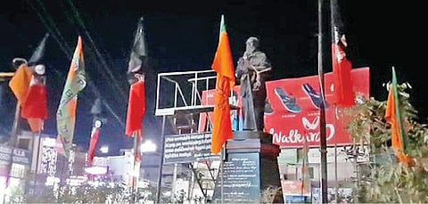 காரைக்குடியில் பெரியார் சிலையைச் சுற்றி கட்டப்பட்டுள்ள பாஜக, அதிமுக கொடி.