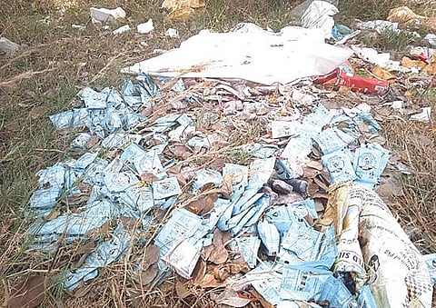 சிவகங்கை காட்டுக்குடியிருப்பு அருகே சாலையோரத்தில் கொட்டிக்கிடந்த ஓஆர்எஸ் பவுடர் பாக்கெட்டுகள்.