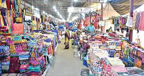 ஈரோடு கனி ஜவுளிச்சந்தைக்கு வியாபாரிகள், வாடிக்கையாளர்கள் வருகை குறைவால் வெறிச்சோடி காணப்படுகிறது.