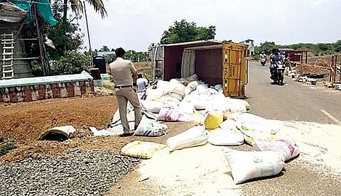மறவமங்கலம் அருகே சரக்கு வாகனம் விபத்துக்குள்ளானதில் சாலையில் சிதறி கிடக்கும் கடத்தல் ரேஷன் அரிசி.