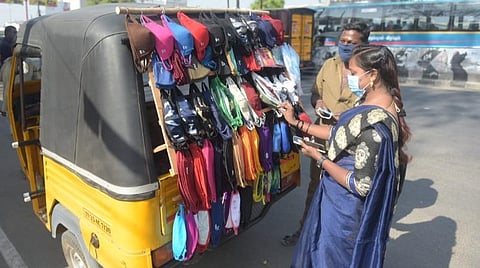 வேலூர் புதிய பேருந்து நிலையம் கிரீன் சர்க்கிள் அருகே ஆட்டோவை சிறு கடையாக மாற்றி, முகக்கவசம் விற்பனை செய்யும் ஆட்டோ ஓட்டுநர் மணி. படம். வி.எம்.மணிநாதன்